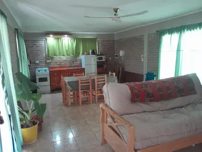 a living room with a couch and a kitchen with a table at Remanso in La Estancia