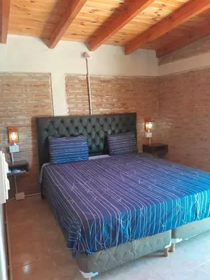 a bedroom with a large bed with a purple comforter at Remanso in La Estancia