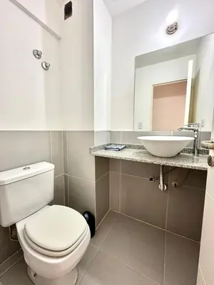 a bathroom with a white toilet and a sink at Departamento Alberdi para 4 personas in Cordoba