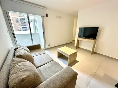 a living room with a couch and a flat screen tv at Departamento Alberdi para 4 personas in Cordoba