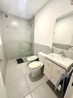 a bathroom with a toilet and a sink and a mirror at Departamento Alberdi para 4 personas in Cordoba