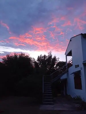a sunset over a building with a stair case at Elsieland in Tanti