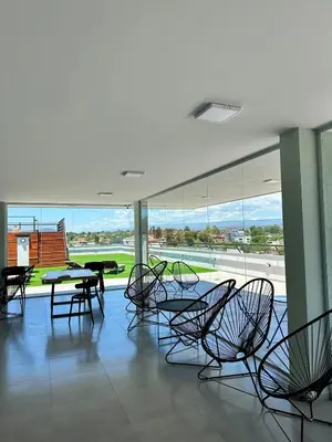 a room with chairs and tables and a large window at Depa de Calidad en el Centro, Piscina in Villa Carlos Paz