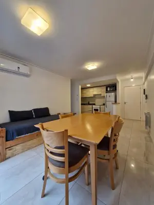 a kitchen and dining room with a wooden table and chairs at Brillante departamento in Cordoba