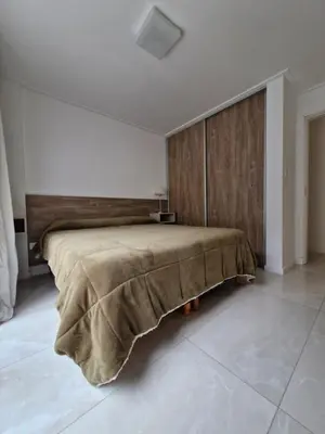 a bedroom with a large bed with a wooden wall at Brillante departamento in Cordoba
