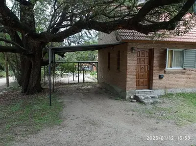 a house with a wooden door and a tree at Los Cachilos in Merlo
