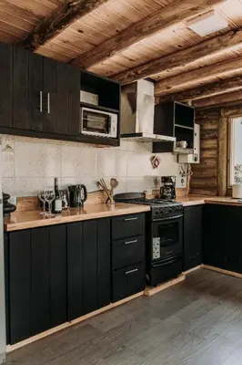 a kitchen with black cabinets and a stove at La Bernardita in Villa Berna