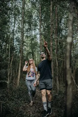 a man and a woman walking in the woods at La Bernardita in Villa Berna
