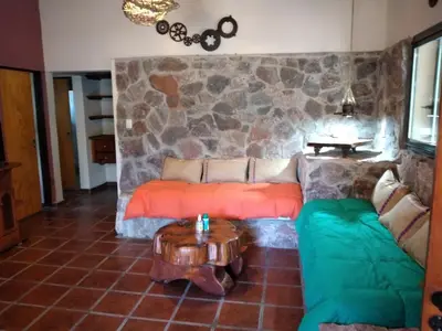 a living room with a couch and a table at Complejo Aguas Calmas - Casa Remanso in Los Reartes