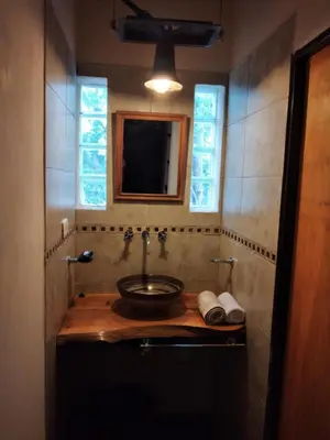 a bathroom with a sink and a mirror at Complejo Aguas Calmas - Casa Remanso in Los Reartes