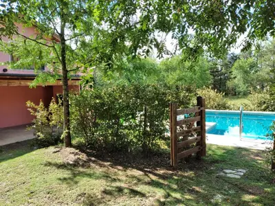 a wooden fence in a yard next to a pool at Complejo Aguas Calmas - Casa Remanso in Los Reartes