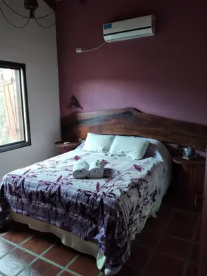 a bedroom with a bed with two towels on it at Complejo Aguas Calmas - Casa Remanso in Los Reartes
