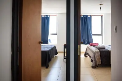 a room with two beds and a room with two windows at Depto centro 2 dorm con cochera in Cordoba