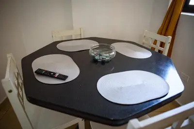 a black table with white plates and a remote control on it at Depto centro 2 dorm con cochera in Cordoba