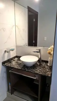 a bathroom with a sink and a large mirror at Depto Nuevo en el Centro, Cochera, Pile, Aire Ac in Villa Carlos Paz