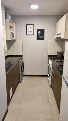 a large kitchen with a washer and dryer in it at Depto Nuevo en el Centro, Cochera, Pile, Aire Ac in Villa Carlos Paz