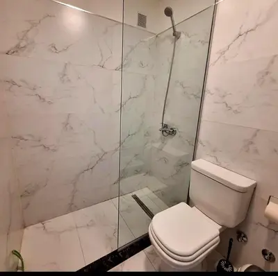 a bathroom with a toilet and a glass shower at Depto Nuevo en el Centro, Cochera, Pile, Aire Ac in Villa Carlos Paz
