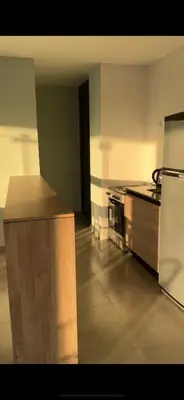 an empty kitchen with a stove and a refrigerator at Departamento Paseo Cibeles in Villa Carlos Paz