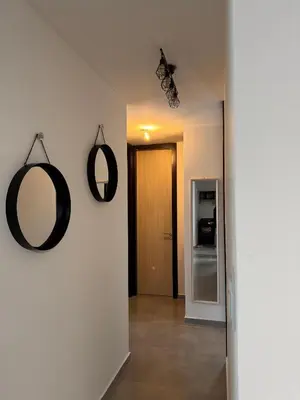 a hallway with two mirrors on a white wall at Departamento Paseo Cibeles in Villa Carlos Paz