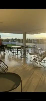 a group of tables and chairs in a room with windows at Departamento Paseo Cibeles in Villa Carlos Paz