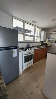 a kitchen with a stove and a refrigerator at Obispo Oro Nueva Cordoba in Cordoba