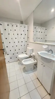 a white bathroom with a toilet and a sink at Obispo Oro Nueva Cordoba in Cordoba