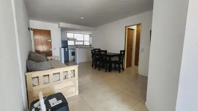 a living room and kitchen with a couch and a table at Obispo Oro Nueva Cordoba in Cordoba