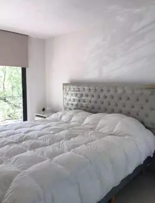 a white bed in a white bedroom with a window at Alquiler Temporal vacaciones in Villa Carlos Paz