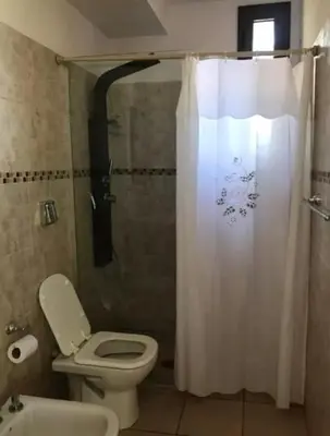 a bathroom with a toilet and a shower with a shower curtain at Alquiler Temporal vacaciones in Villa Carlos Paz