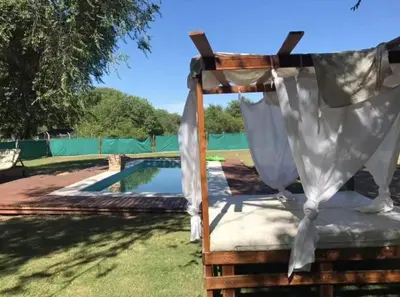 a bed with a canopy next to a pool at Alquiler Temporal vacaciones in Villa Carlos Paz