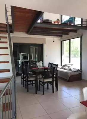 a dining room with a table and chairs and a bed at Alquiler Temporal vacaciones in Villa Carlos Paz