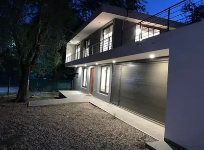 a house with a garage door in front of it at Alquiler Temporal vacaciones in Villa Carlos Paz