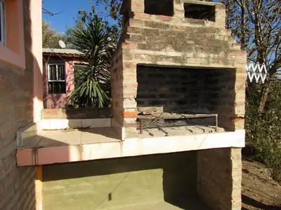 an outdoor pizza oven with a brick wall at CABAÑAS SANTA RITA - Tanti, Córdoba in Tanti