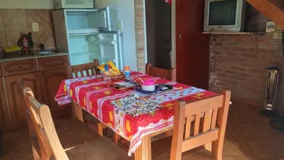 a table in a kitchen with a table cloth on it at CABAÑAS SANTA RITA - Tanti, Córdoba in Tanti
