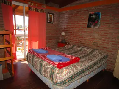 a bed in a room with a brick wall at CABAÑAS SANTA RITA - Tanti, Córdoba in Tanti