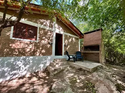 a brick house with a table and chairs in front of it at Atrapa Sueños I in Embalse