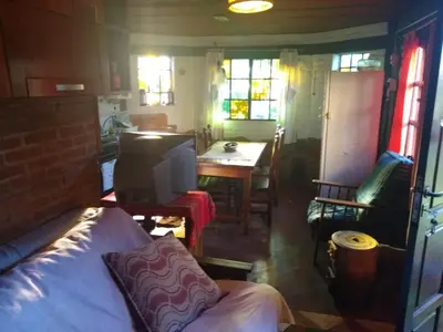 a room with a bed and a table and a kitchen at Casita Loma Hermosa in Mina Clavero