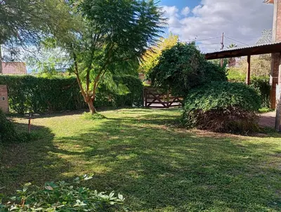 a park with a bench and a tree and grass at Casita Loma Hermosa in Mina Clavero