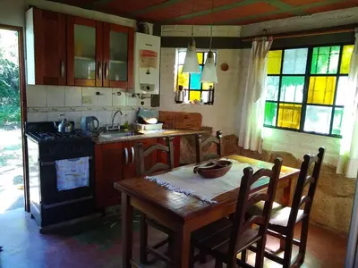 a kitchen with a wooden table and a stove at Casita Loma Hermosa in Mina Clavero