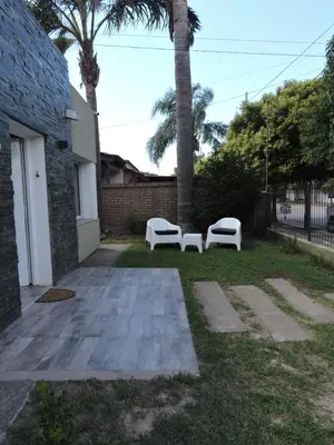 two white benches in a yard with palm trees at Algarrobo in Almafuerte