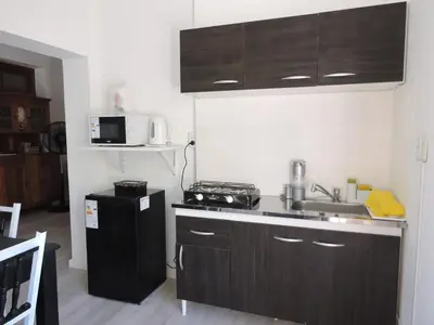 a kitchen with brown cabinets and a sink and a microwave at Algarrobo in Almafuerte