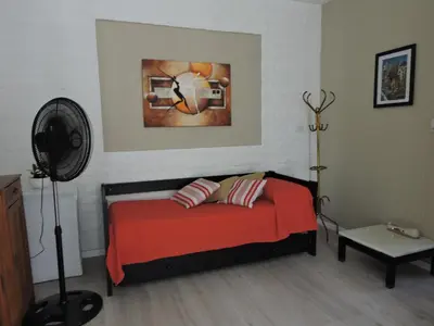 a bedroom with a bed with red sheets and a fan at Algarrobo in Almafuerte