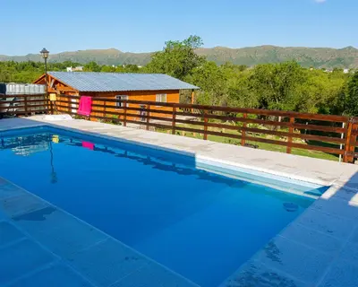 a swimming pool in front of a cabin at CABAÑAS La Perla in Bialet Massé