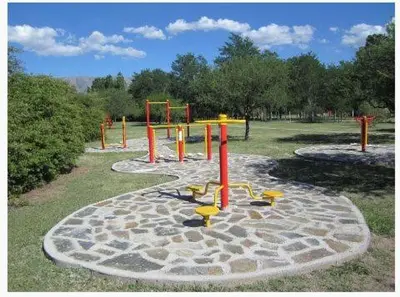 a playground in a park with red and yellow equipment at Las Icarias Casas de campo in Las Calles