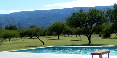 a swimming pool with a chair and trees in a field at Las Icarias Casas de campo in Las Calles