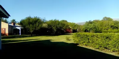 a yard with green grass and trees and a house at Las Icarias Casas de campo in Las Calles