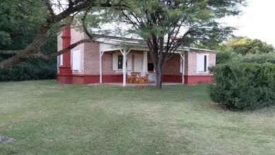 a red and white house with a tree in the yard at Las Icarias Casas de campo in Las Calles