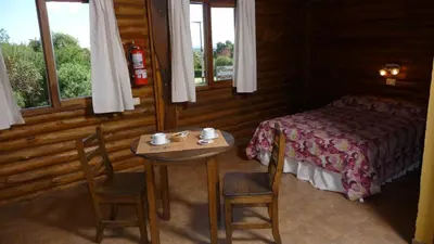 a bedroom with a table and two chairs and a bed at Rincón de los Troncos in Merlo