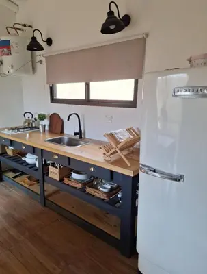 a kitchen with a sink and a white refrigerator at Cabañas Posada del Angel in Villa Serranita