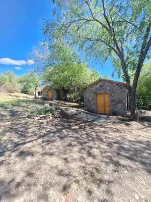 a small building with a tree in front of it at Cabañas Posada del Angel in Villa Serranita